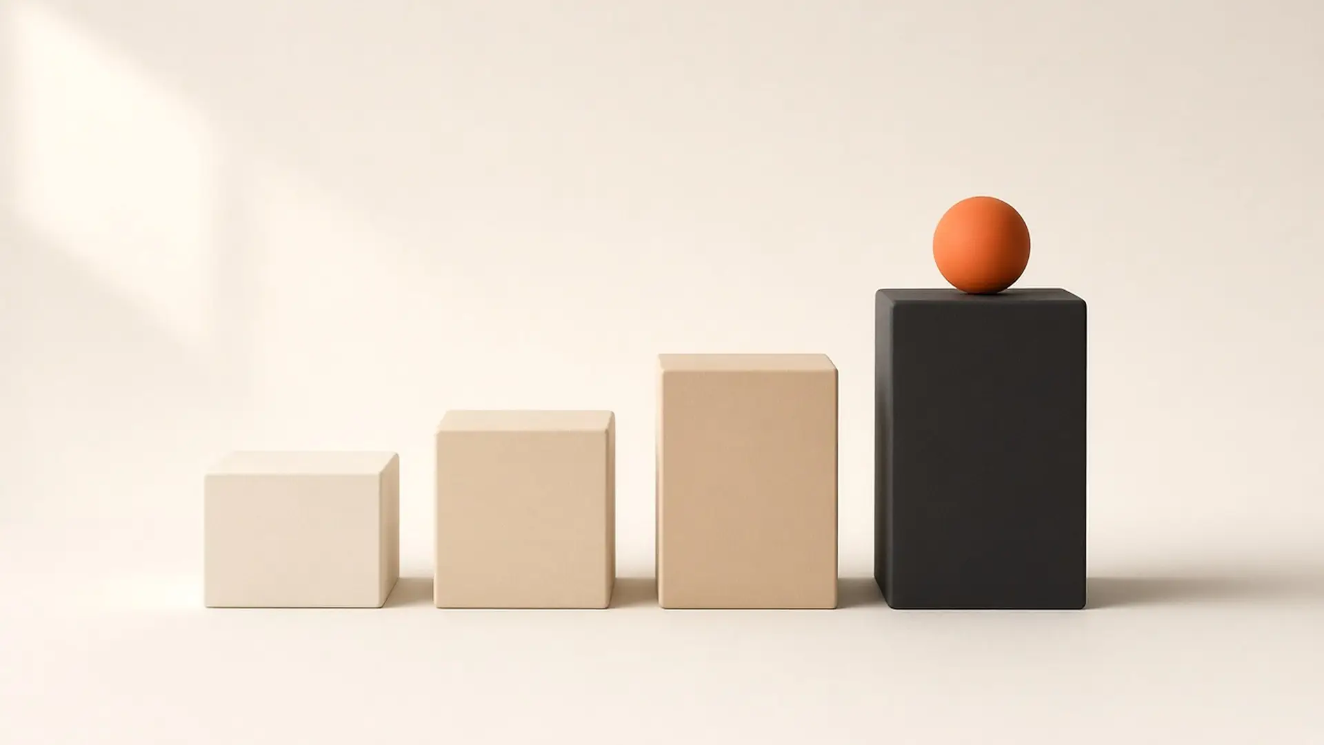 Four blocks rising in height from cream to black, with an orange ball on the tallest.